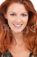 Flaming beauty. Closeup of a gorgeous smiling redhead with a perfect complexion, isolated on white - copyspace.