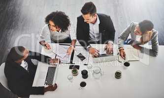 Their important meeting is under way. High angle shot of a group of businesspeople having a meeting in an office.