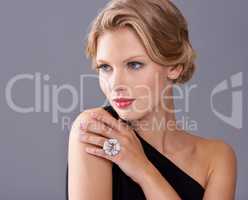 Timeless sophistication and chic. A gorgeous young woman in an evening gown while isolated on a grey background.
