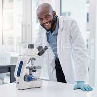 Science and everyday life cannot and should not be separated. Shot of a young scientist using a microscope in a laboratory.