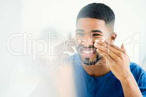 Ive never had a more moisturizing face cream. Shot of smiling young man applying face cream.