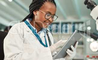 Sharing the news of her latest discovery. Shot of a young scientist using a digital tablet in a lab.