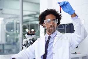 Let the analyzing begin. Shot of a male medical scientist holding a test tube filled with blood.