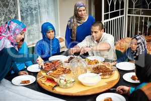 Dig in everyone. Shot of a muslim family eating together.