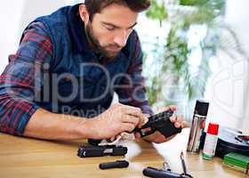 Regular maintenance is essential for every gun owner. A young man cleaning his gun.