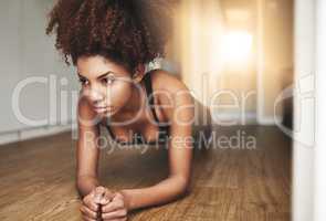 I only compete with myself. Shot of a young woman working out at home.