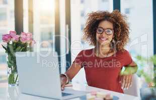 With business technology, companies can target a wider customer base. Shot of a young businesswoman sitting at her desk.