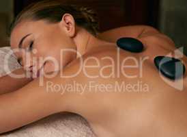 Being pampered from top to toe. A young woman lying with her eyes closed on a massage bed.