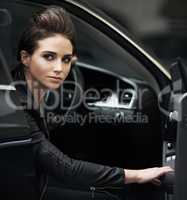 Stylish chic in her luxury car. A gorgeous leather-clad woman sitting in her luxury vehicle.