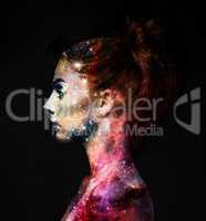 Intergalactic beauty. Profile of a young woman with the galaxy overlaid on her face.