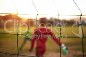 Life is like soccer - you need goals. Defocused shot of young boys playing soccer on a sports field.