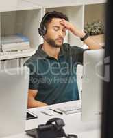 The work of a call center agent is complex and demanding. Shot of a businessman looking stressed while working in a call center.