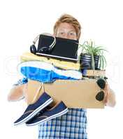 Making a move. A young red-headed man carrying a box filled with his belongings - isolated.