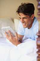 Some silent company. Cropped shot of a handsome young man using his digital tablet at home.