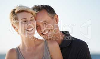 Making each other laugh. Shot of a mature couple enjoying a day at the beach.