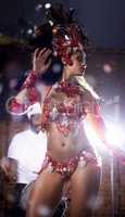 Ravishing in red. Shot of a beautiful samba dancer performing in a carnival with her band.