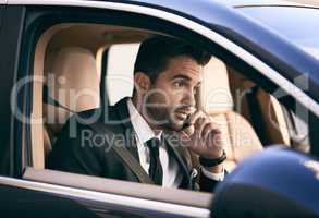 Im headed into the office right now. Cropped shot of a handsome young businessman making a phonecall while on his morning commute to work.