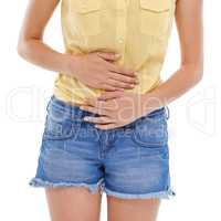 Must have been something I ate. A cropped view of a young womans waist as she experiences stomach cramps.