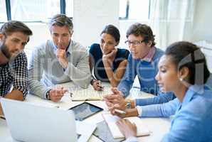 Faster, more efficient meetings with the help of technology. A group of business colleagues discussing work on a laptop during a boardroom meeting.