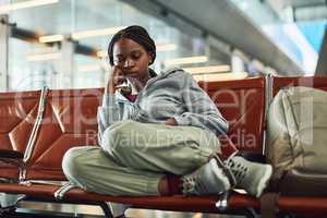 Traveling can be tiring. Shot of a young woman falling asleep at the airport while waiting for departure.