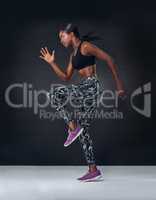 Owning that cardio workout. Studio shot of a beautiful young woman jogging on the spot against a black background.