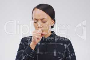 Its that time of the year again. Studio shot of an attractive young woman coughing against a grey background.