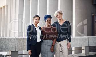 Surround yourself with strong women. Portrait of a group of businesswomen standing together against a city background.