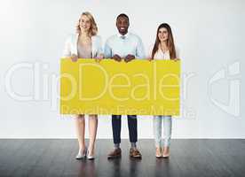 Well carry your message across. Studio shot of a group of businesspeople holding up a blank yellow placard.