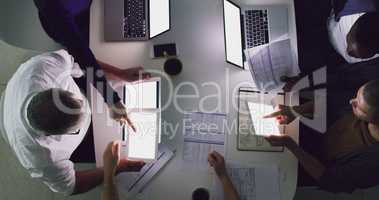 Sometimes longer hours are required. High angle shot of a group of businesspeople working together around a table in their office.