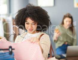 The price tag is quite convincing. Cropped shot of a young woman shopping for clothes in a store.