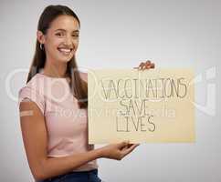 Currently sticking it to COVID-19. Shot of a young woman standing alone in the studio and holding a poster after getting vaccinated.