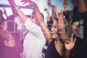 Thats my favourite song. Cropped shot of an attractive young woman cheering while standing in the crowd at a concert at night.