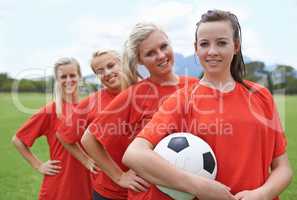 Together theyll win. Portrait of a young female soccer player and her teammates.