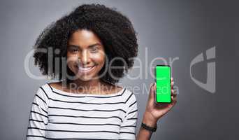 This app needs to be on your download list. Studio portrait of a young woman showing a smartphone with a green screen against a gray background.