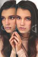 There are two sides to you and both are beautiful. Portrait of a beautiful young woman leaning against a mirror.