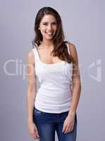 Shes got a bubbly personality. Smiling young woman standing casually against a grey background.