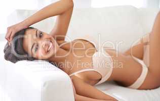 Feminine features. Portrait of a gorgeous young woman lying on the sofa in her lingerie.