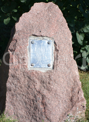 metal plate on granite stone in park at dry sunny summer day