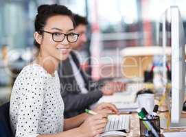 Make creativity a job. Shot of a young office worker sitting at her workstation in an office.