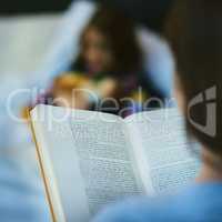 This story leaps off the page. Blurred shot of a mother reading a bedtime story to her daughter.