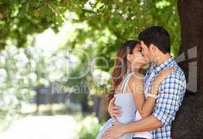 No else in the world right now.... A young couple kissing in the park.