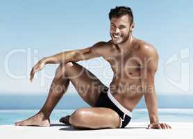 Charming and chiseled. Shot of a muscular naked man basking in sunlight.