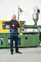 This factory is a well-oiled machine. Full length portrait of a mature man standing next to machinery in a factory.