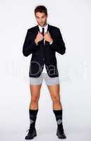 Dressed to make an impression. Handsome young guy wearing a formal jacket and no pants against a white background.