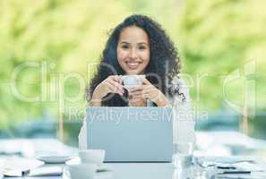 Queen of the corporate jungle. Shot of a young businesswoman drinking a cup of coffee while sitting at her desk.