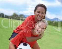 Best friends and teammates. Shot of a female soccer player carrying her teammate on her back.