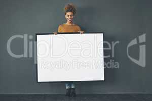 Ill advertise your message. Studio portrait of a young woman holding a blank sign against a grey background.