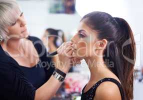 Backstage beauty. A young woman having makeup applied.