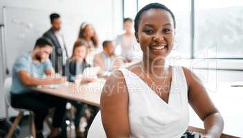 My seat at this table is guaranteed. Cropped portrait of an attractive young businesswoman attending a meeting in the boardroom with her colleagues in the background.