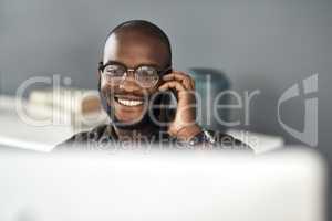 Connect to people who keep business buzzing. Shot of a young businessman using a smartphone and computer in a modern office.